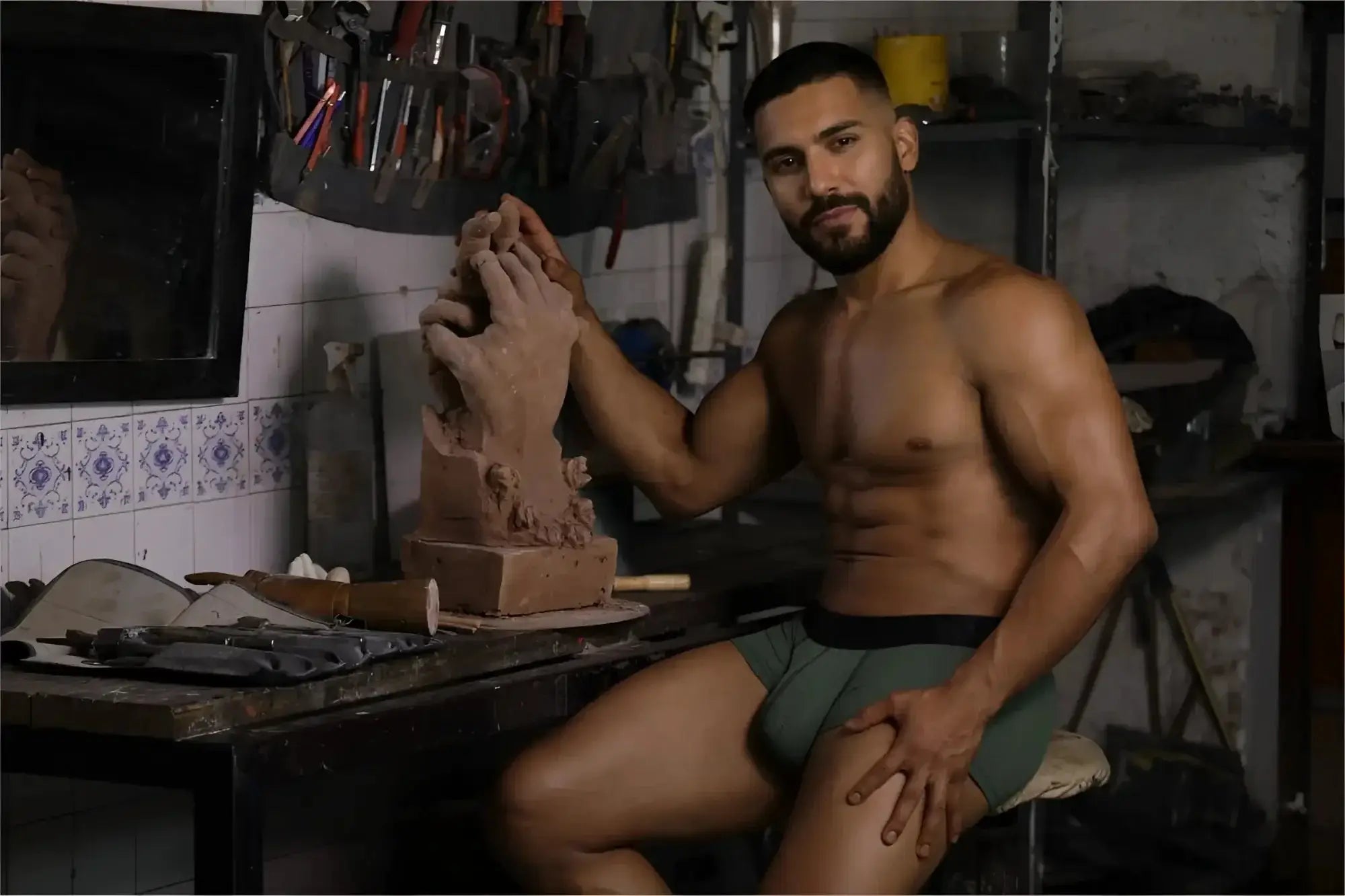 Lifestyle shot of a man wearing Xtremen 91252 Microfiber Mesh Trunks in Military Green while working with clay.