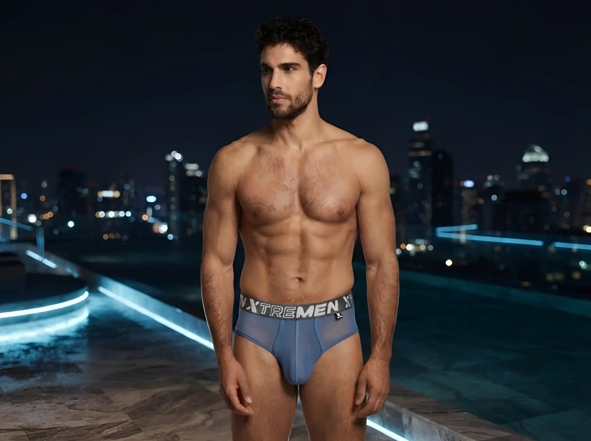 Xtremen blue mesh brief with branded elastic waistband, worn by a model at night.